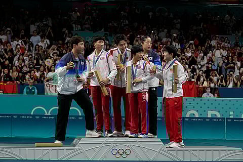 South Korea's Lim Jonghoon, left, prepares to take a selfie during table tennis medal ceremony
